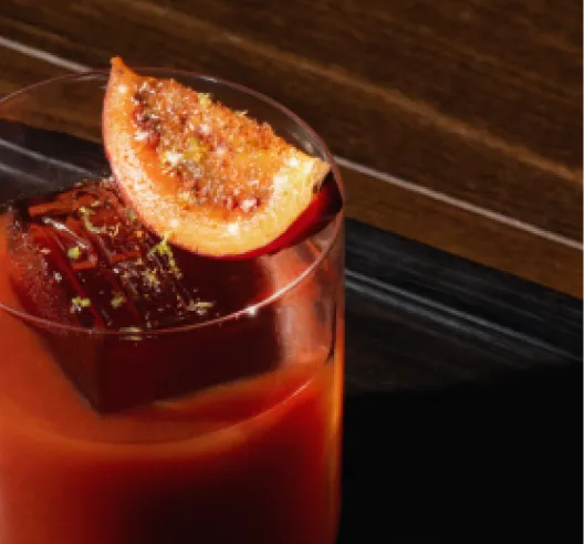 Bloody Mary cocktail with a slice of orange and garnish in a glass.